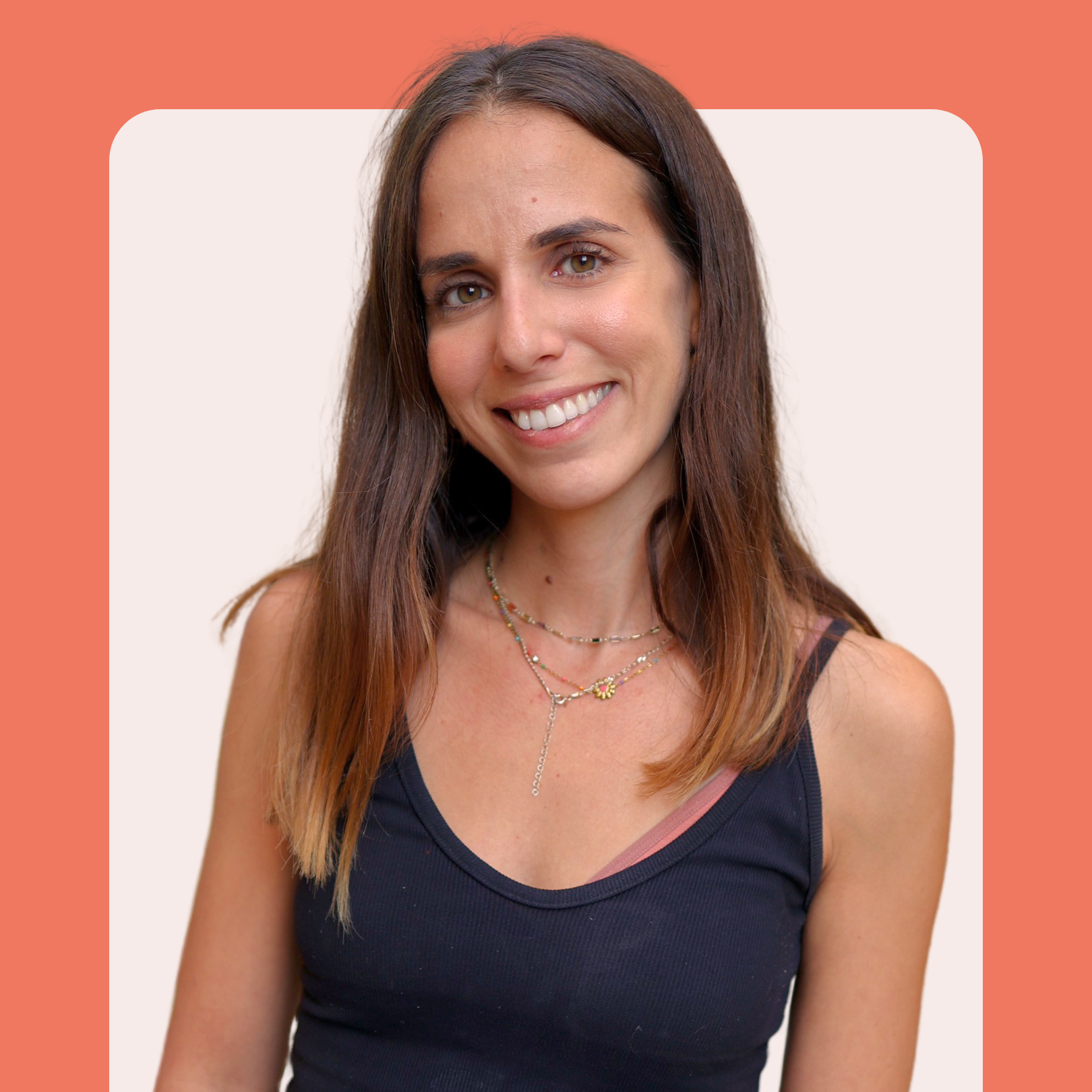 A woman with long brown hair, wearing a black tank top and layered necklaces, smiles at the camera. The background is light beige with rounded corners and a coral border at the top.