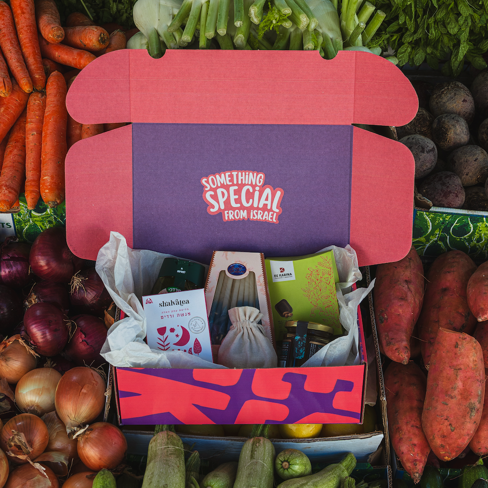 Chanukah gift box with Israeli artisanal products and fresh vegetables background