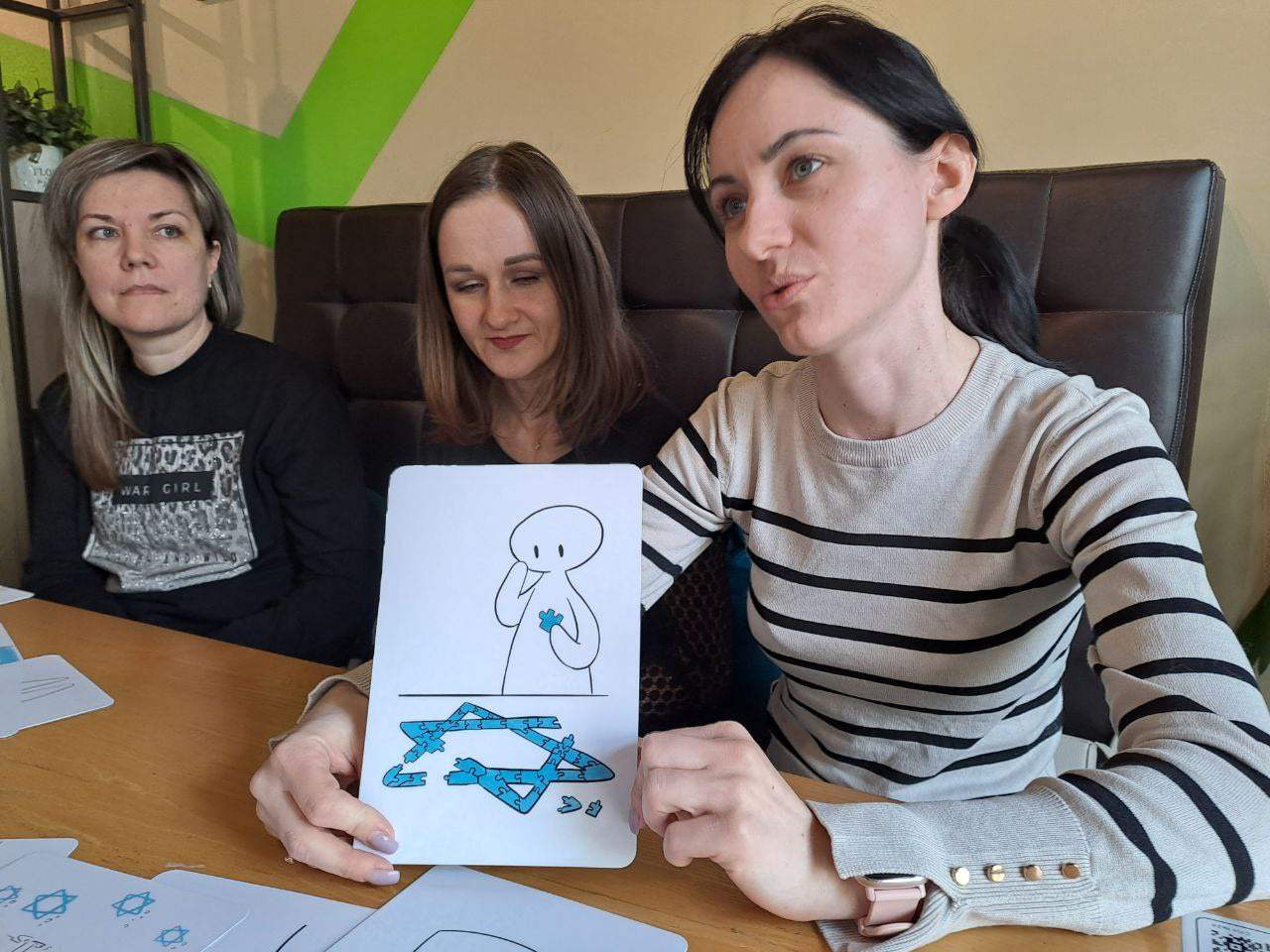 Women engaging with David Cards Israel education card set, featuring Star of David illustration for Jewish identity exploration.