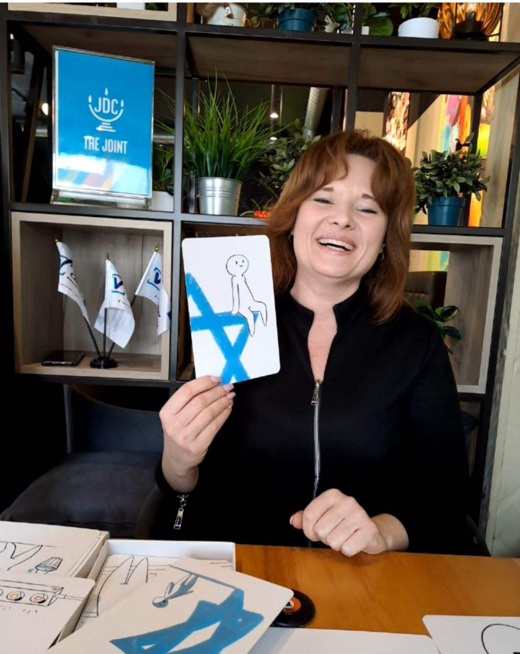 David Cards Israel Education Card Set presentation with a smiling person holding an illustrated card featuring the Star of David.