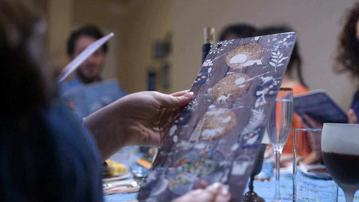 The Recreated Haggadah interactive card being held during a Passover Seder.