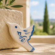 ADI Shalom Dove Magnet, cream ceramic dove with blue Hebrew lettering, blue eye, and hand-painted feather details.