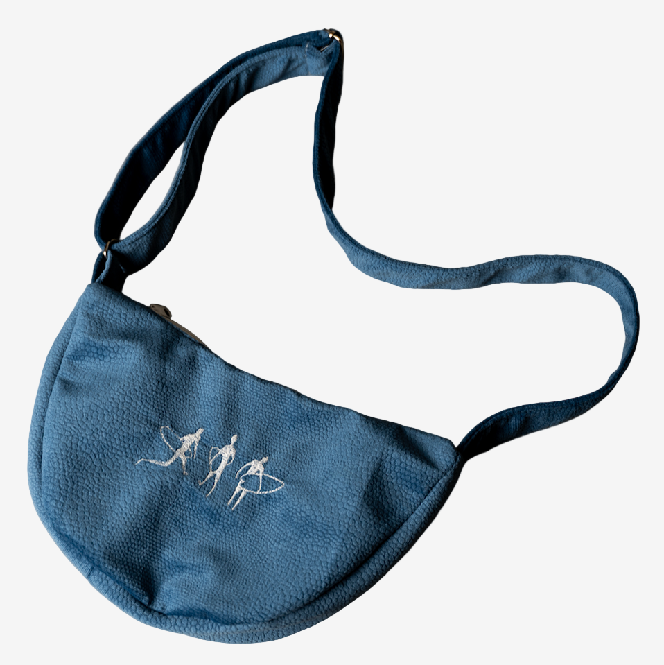 Hand sewn blue suede shoulder bag with white embroidered surfboard illustration and adjustable strap