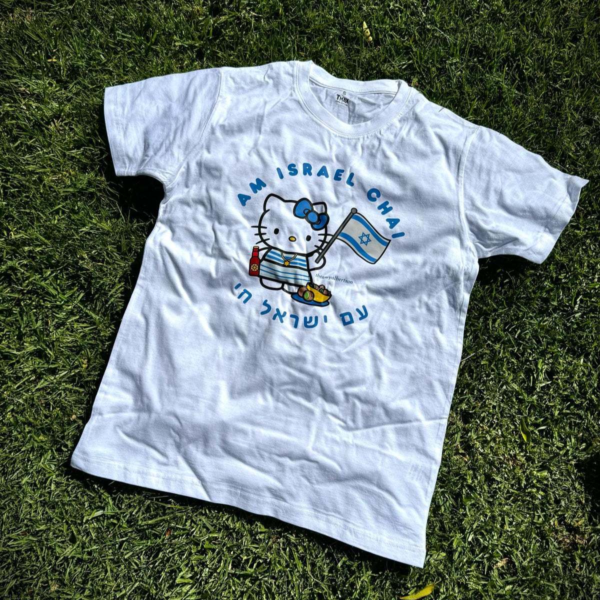 Cute Am Israel Chai kitty t-shirt with falafel and flag design on grass.