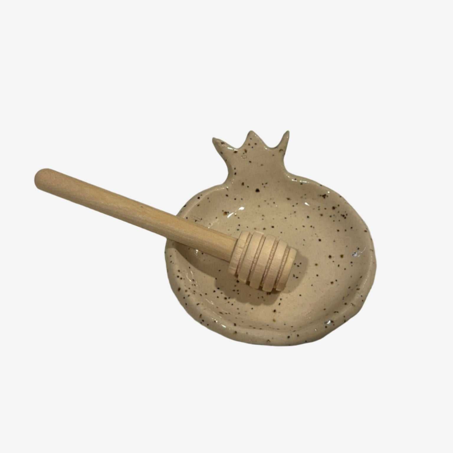 Handcrafted speckled ceramic honey dish shaped like a pomegranate with wooden honey dipper