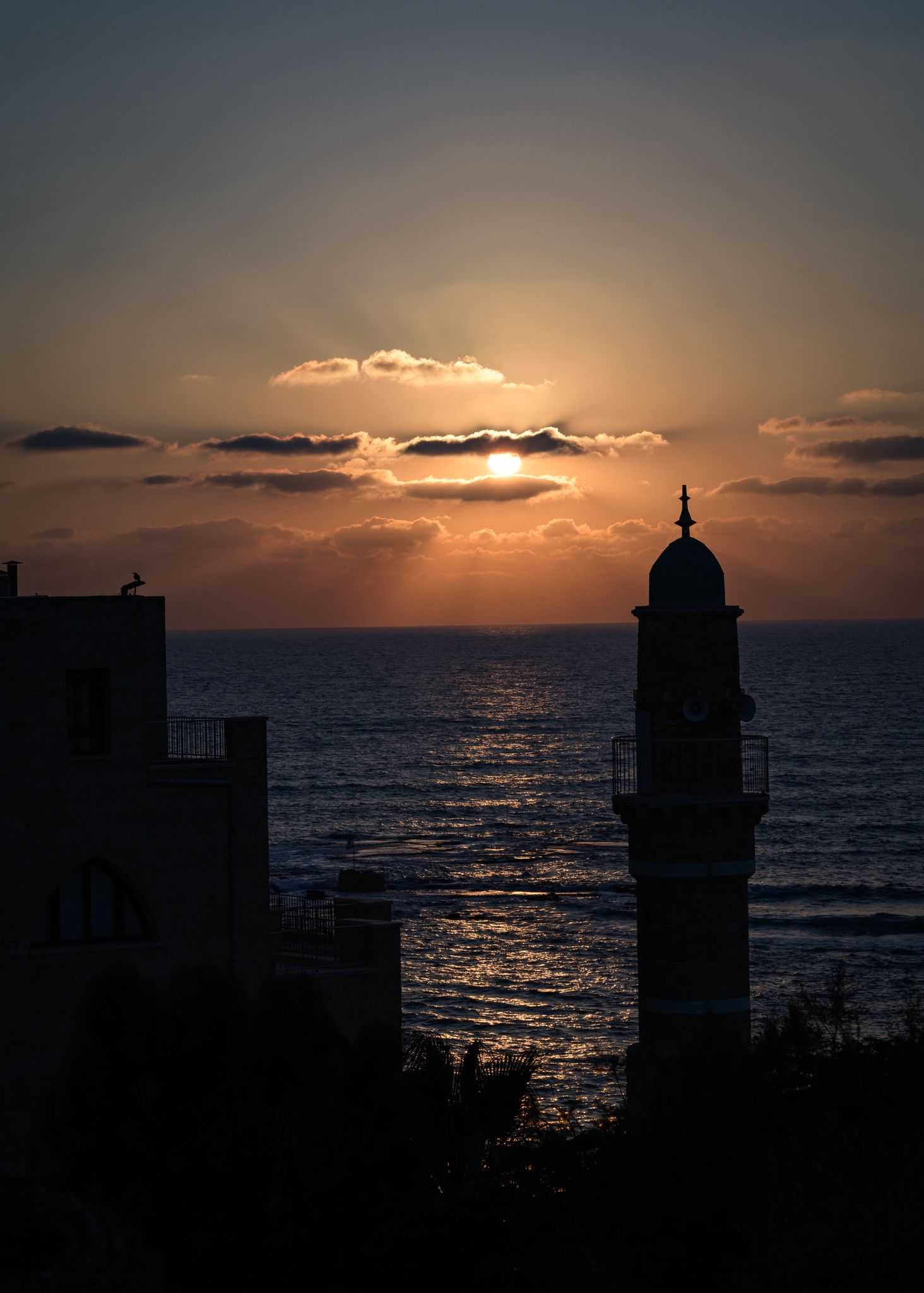 Sunset seascape with silhouetted lighthouse and buildings framed photographic print titled Anticipation Framed Print by Shye Klein