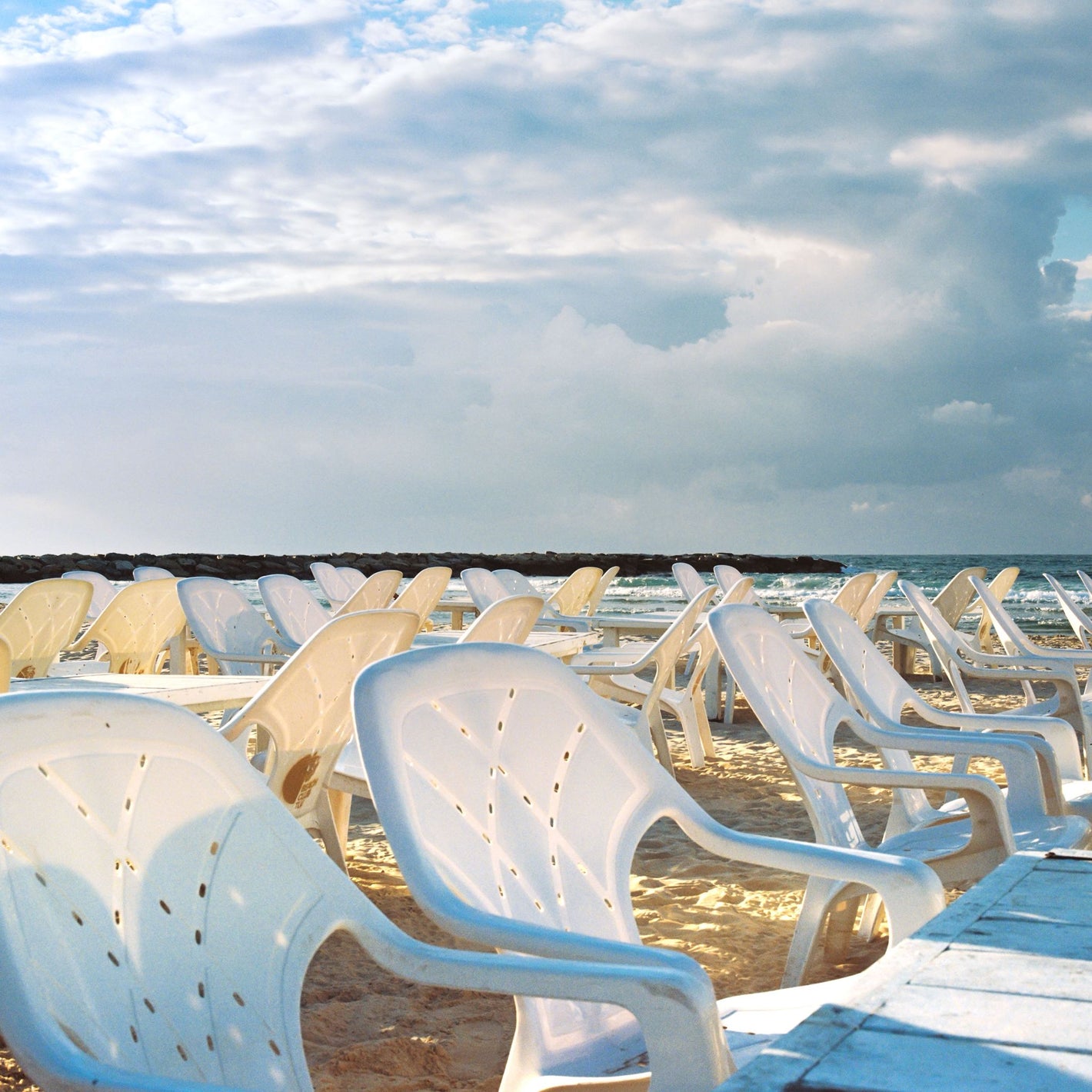 Empty white chairs facing sea at Charles Clore Beach, Tel Aviv, Anticipation framed print by Shye Klein