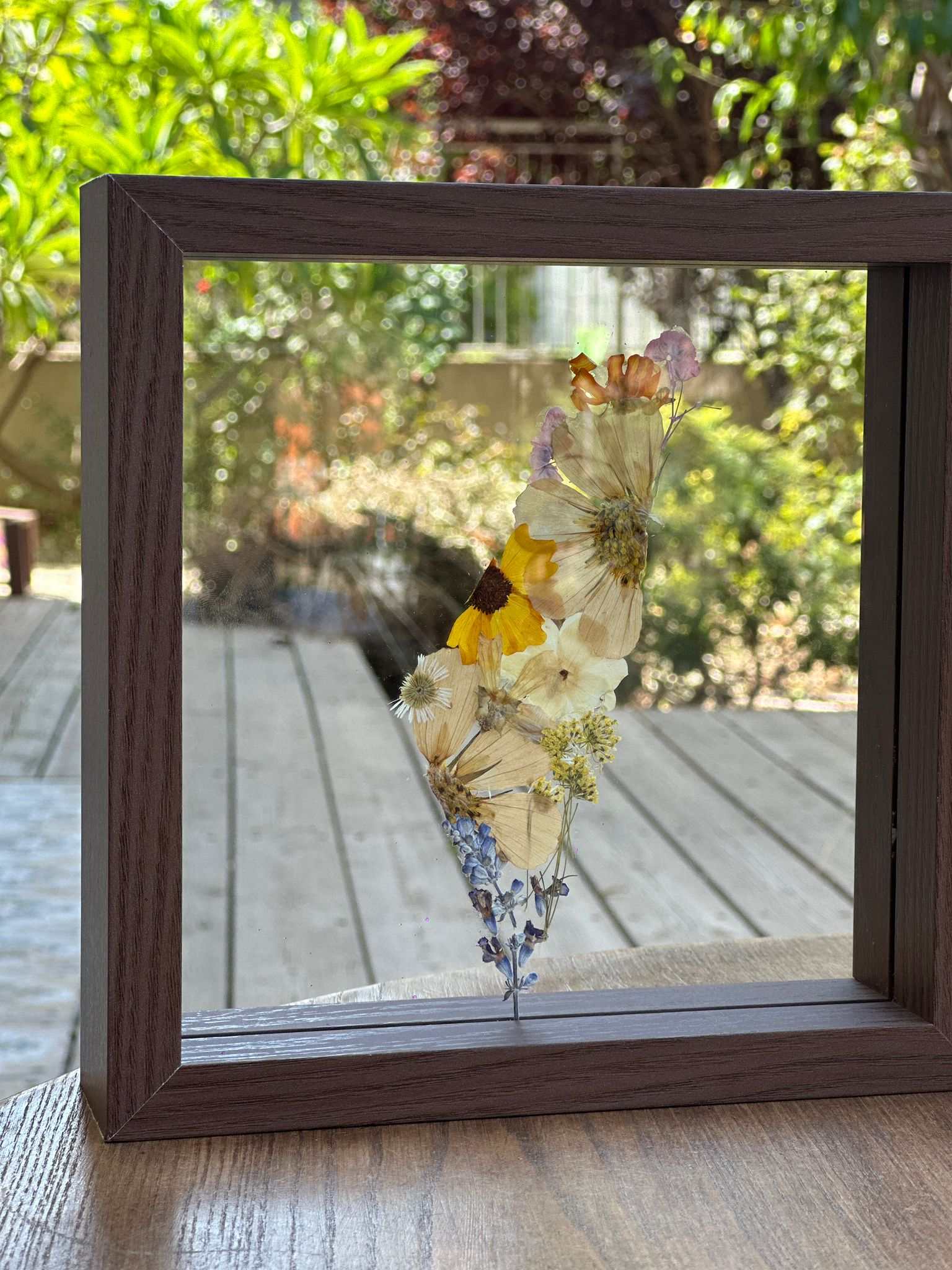 Pressed flowers framed map of Israel in natural wood frame with glass layers showing vibrant floral artwork