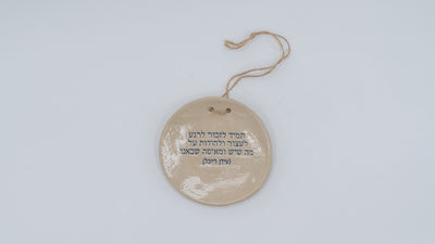 ADI Inspirational Quote Hanging Plate, round beige ceramic with a glossy finish, Hebrew text, and a hanging cord.