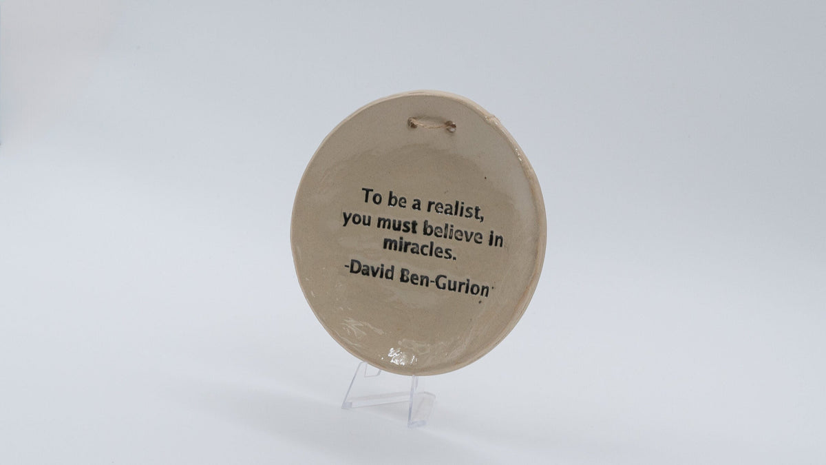 ADI Inspirational Quote Hanging Plate, round beige ceramic with a black David Ben-Gurion quote and hanging hole