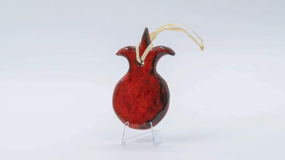 ADI Pomegranate Wall Decoration in glossy red ceramic, with a dark speckled finish and gold hanging cord.