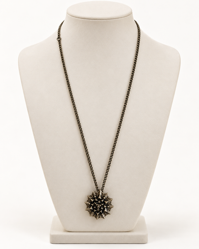 Nova Heaven Burning Man Necklace with a dark bronze-toned chain and spiky geometric sunburst pendant, likely metal.