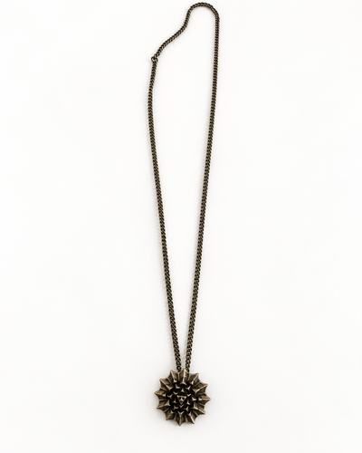 Nova Heaven Burning Man Necklace with a dark bronze-toned chain and sculptural, spiked sunburst pendant.