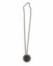 Nova Heaven Burning Man Necklace with a silver-tone chain and geometric spiked sunburst pendant in a layered design.