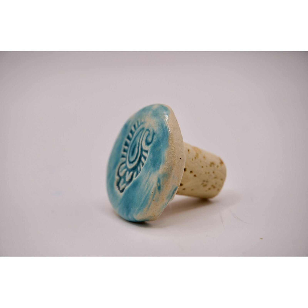 Bottle stopper with a turquoise, hand-painted ceramic top and cork base, featuring a raised decorative motif; ADI Hand-Painted Ceramic item.