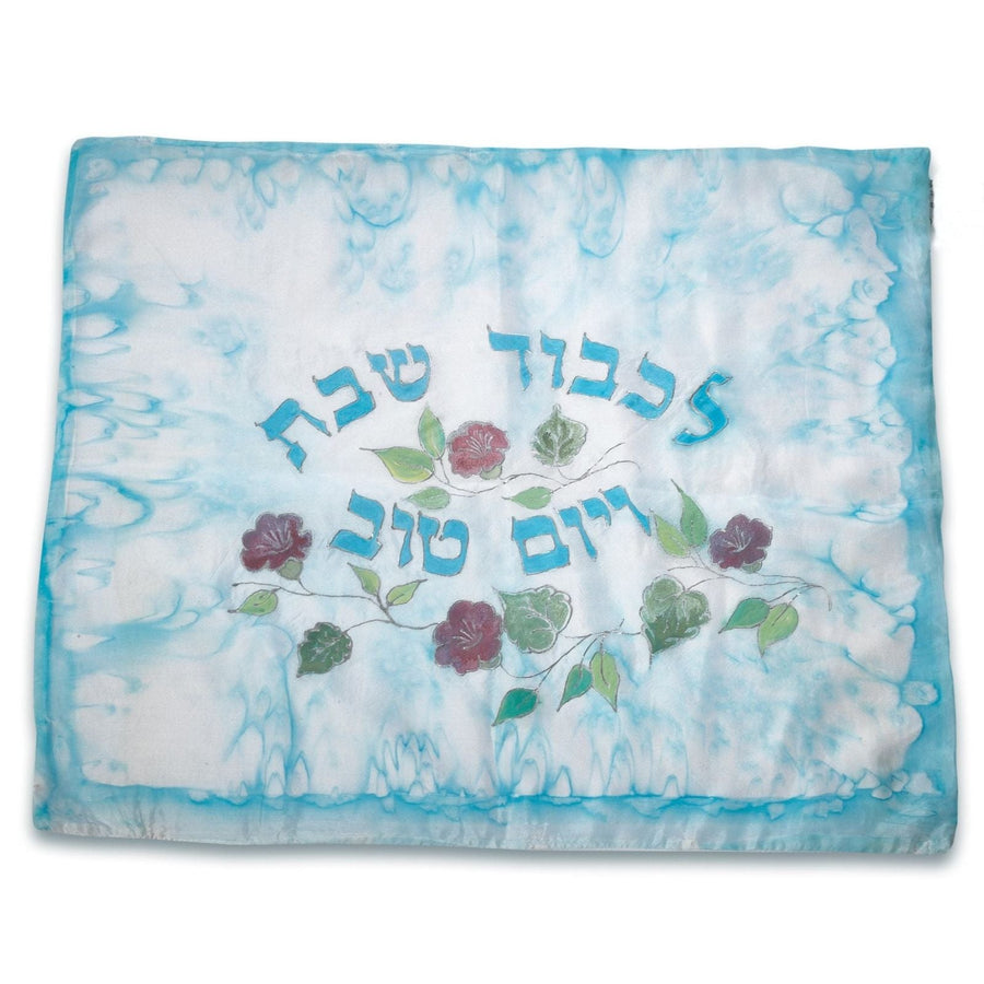 ADI Challah Cover in blue and white fabric with a watercolor-style border, Hebrew lettering, and embroidered flowers and leaves.