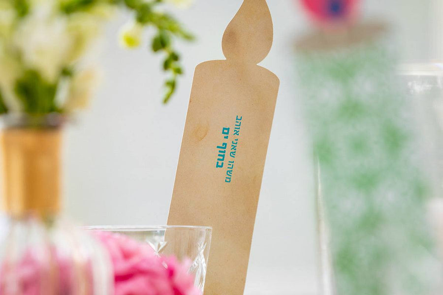 Light Up! Family Conversation Game with a kraft-brown candle-shaped card, printed with small turquoise text and a flame tip.