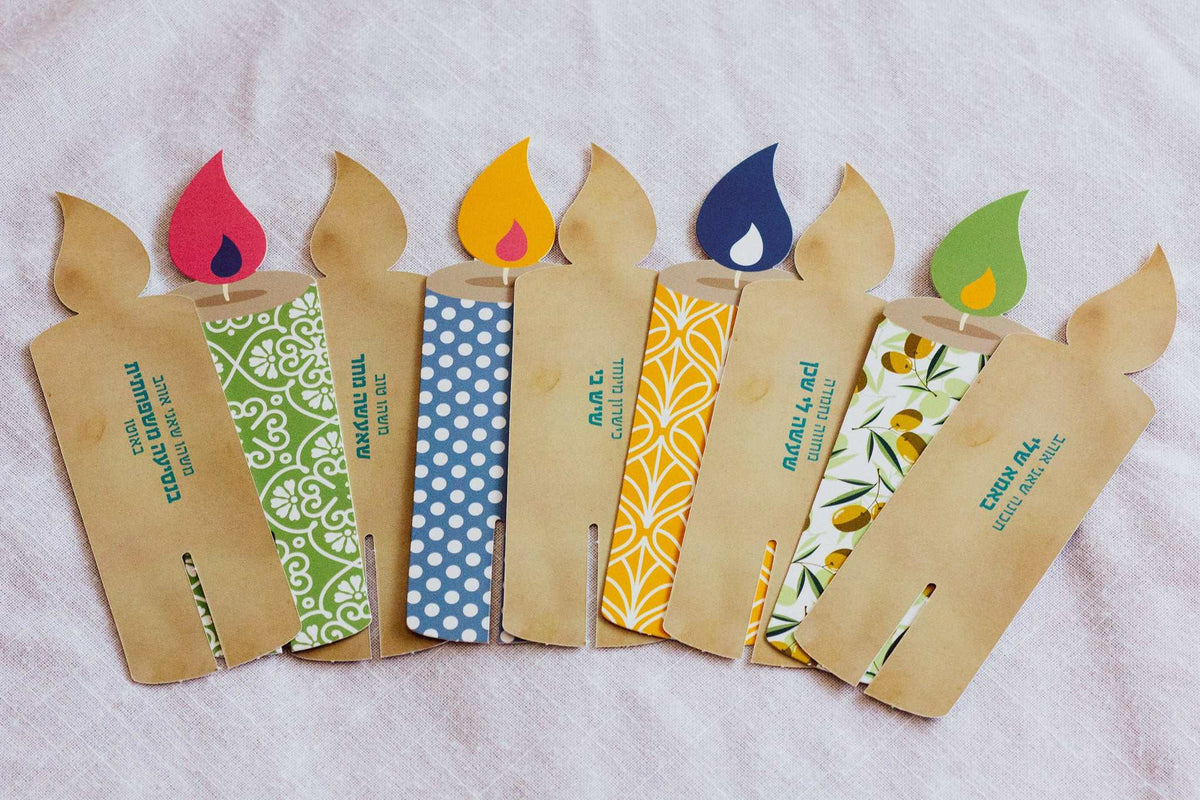 Light Up! Family Conversation Game with kraft paper candle-shaped cards, colorful patterned panels and flame-shaped tops.