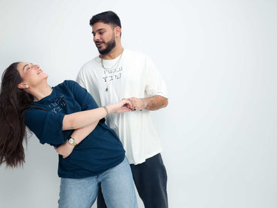 Navy cotton T-shirt with white Hebrew lettering, worn by a woman; Omer Wenkert Now Is Good collection piece