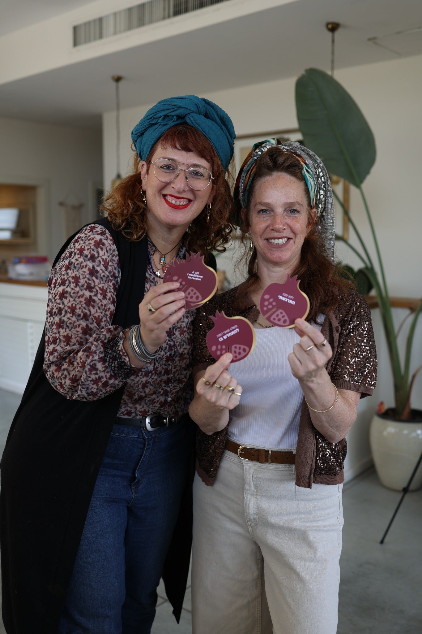 Two women sharing handmade pomegranate pieces at an ESEK gathering
